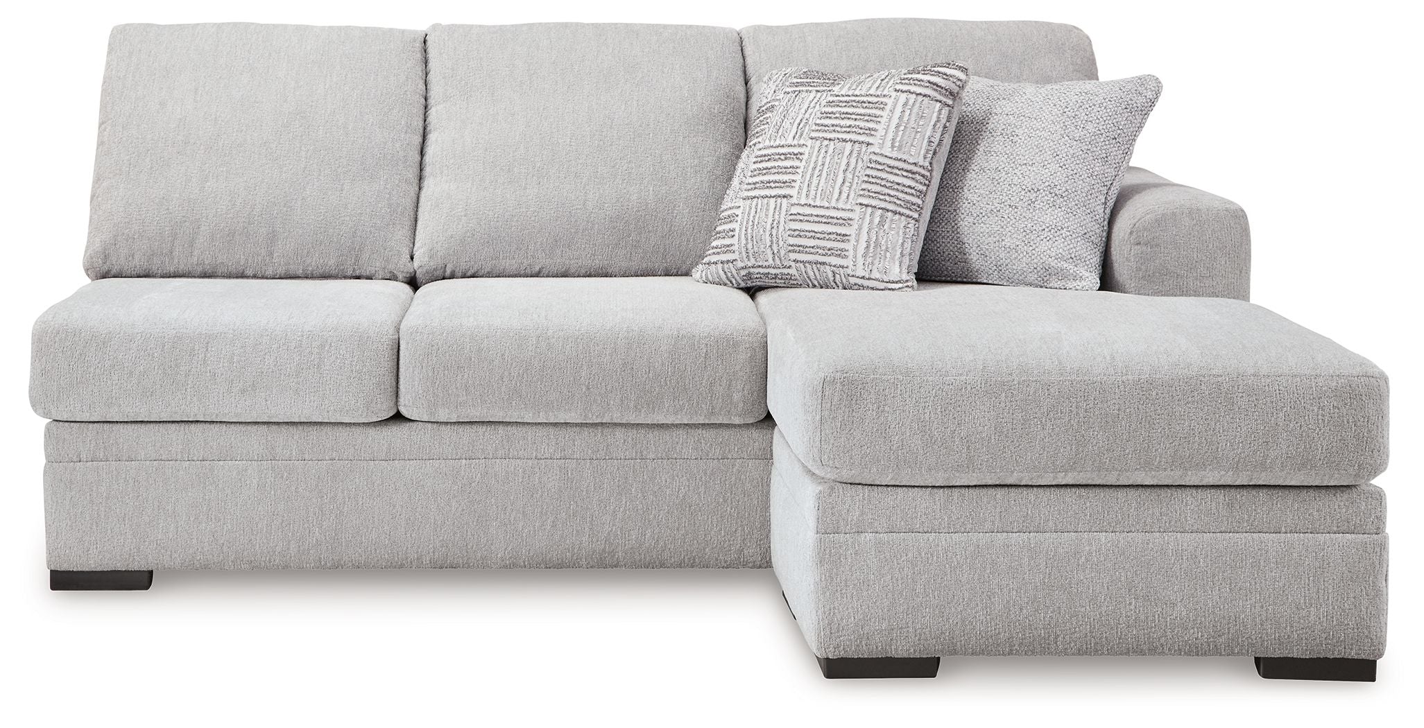 Light gray chaise sofa section with tufted back cushions and patterned throw pillow