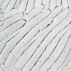 White vase close-up with textured vertical stripes and speckled finish