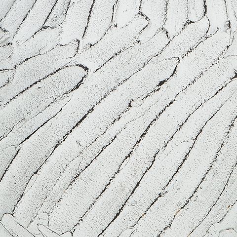 White vase close-up with textured vertical stripes and speckled finish