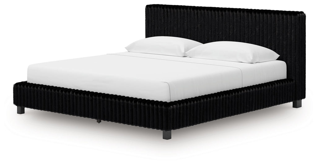 Upholstered bed with black ribbed headboard, black base, white mattress and pillows