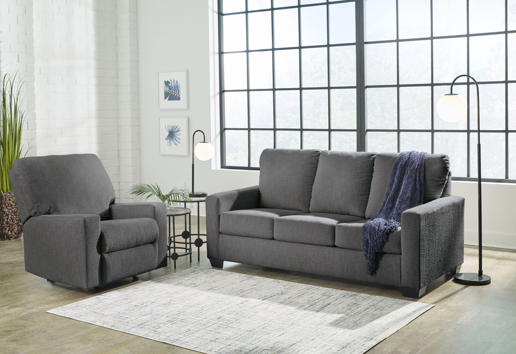 Dark gray sofa set with matching armchair, blue throw draped over the sofa