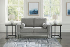 Charcoal loveseat with rolled arms and two round accent pillows in front view