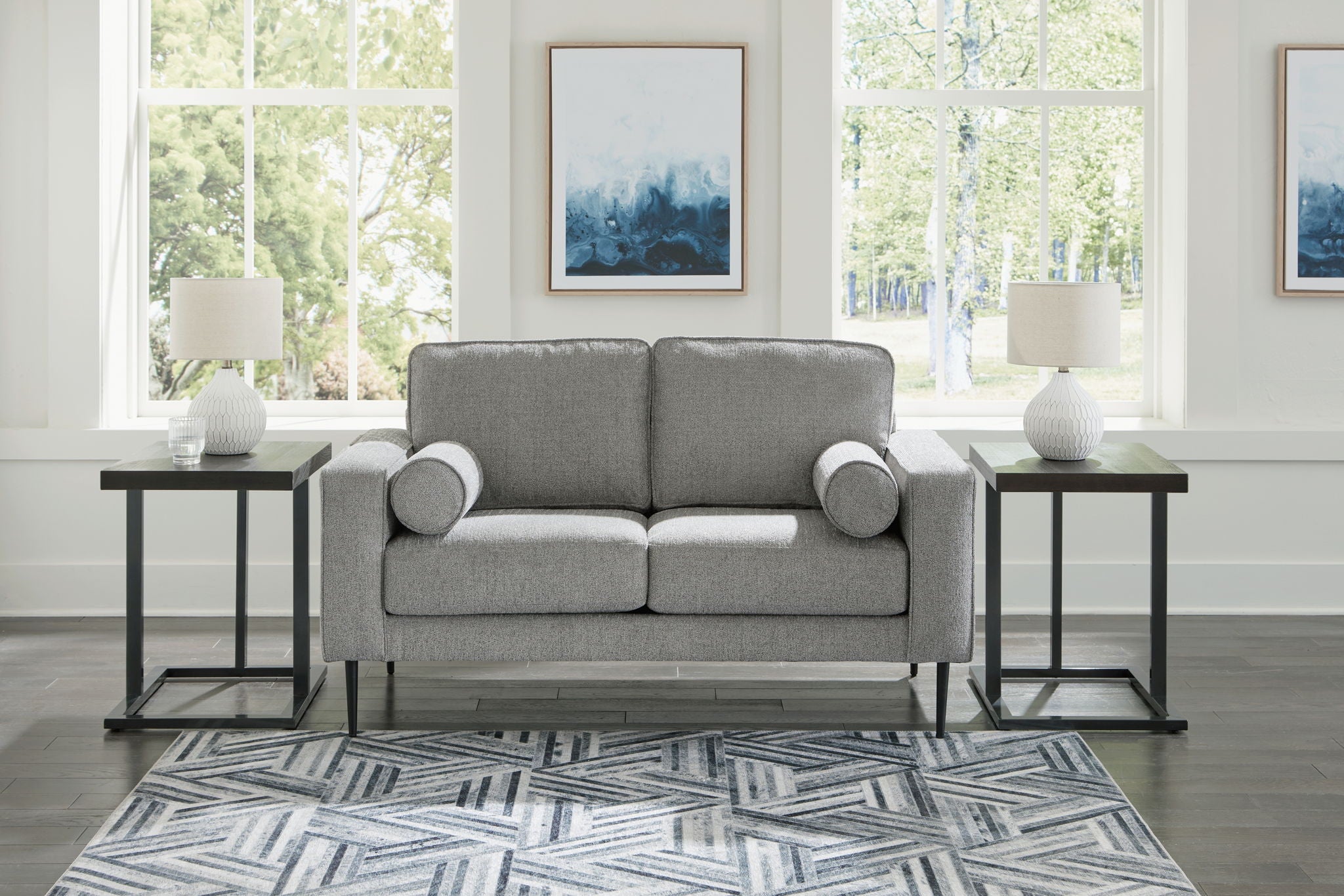 Charcoal loveseat with rolled arms and two round accent pillows in front view