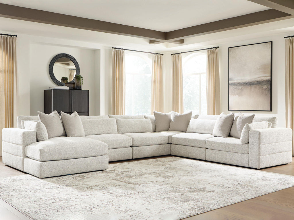 Beige sectional sofa with corner and chaise, fabric upholstery, padded seat cushions and pillows