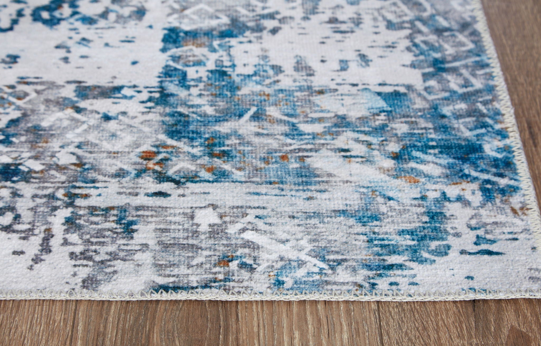 Blue and white abstract rug corner with low-profile woven texture