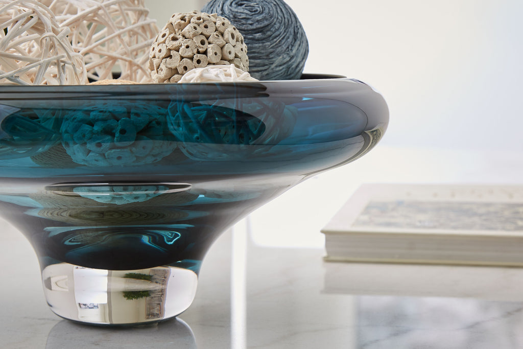 Teal blue glass bowl with dark rim, side view