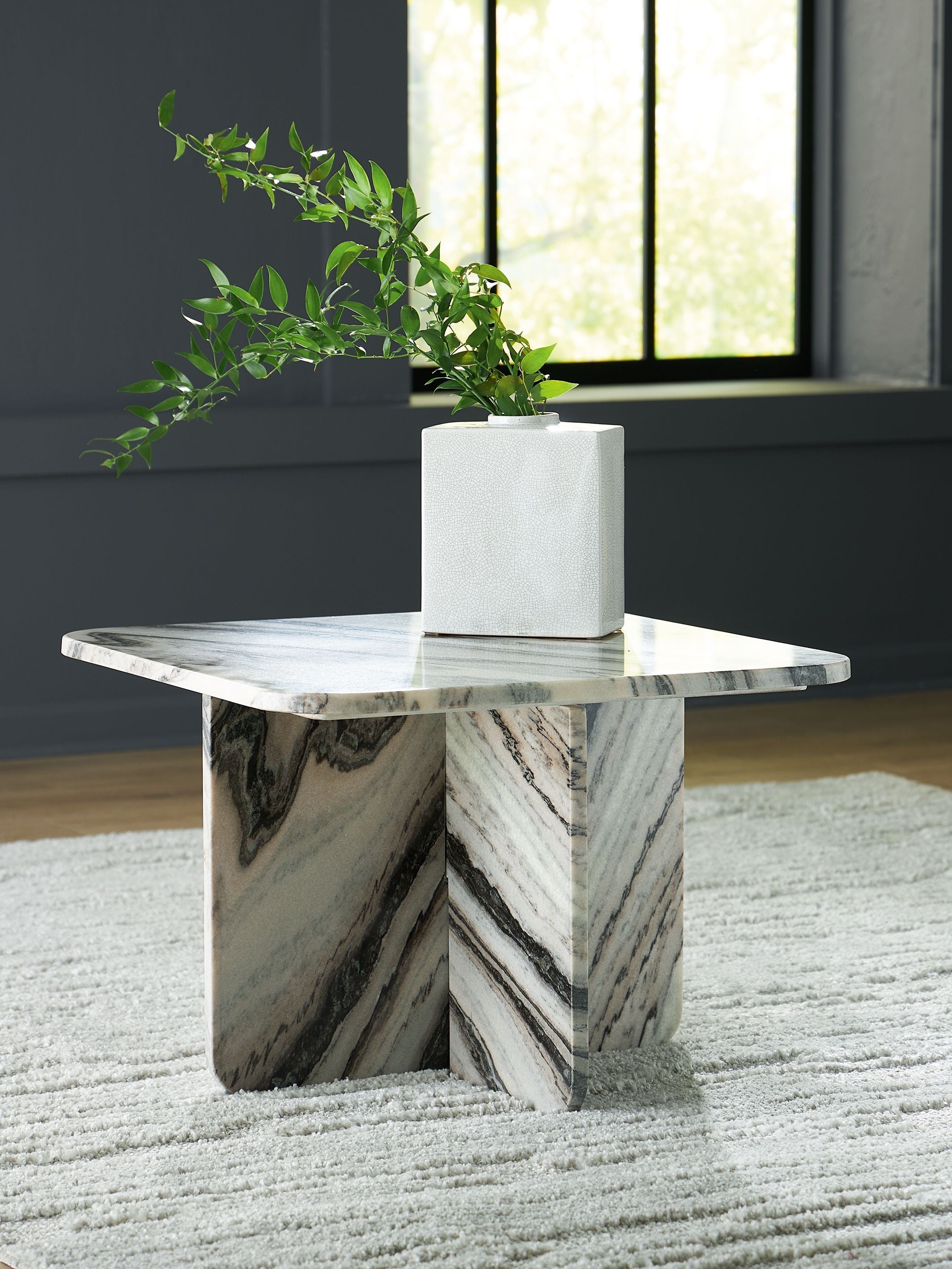 Accent cocktail table with veined white marble-look top and angled pedestal base