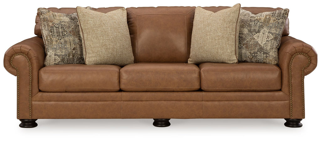 Caramel leather sofa front view with rolled arms and four accent pillows