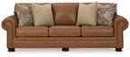 Caramel leather sofa front view with rolled arms and four accent pillows