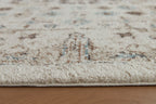 Beige area rug surface with distressed motif details in brown and blue-green