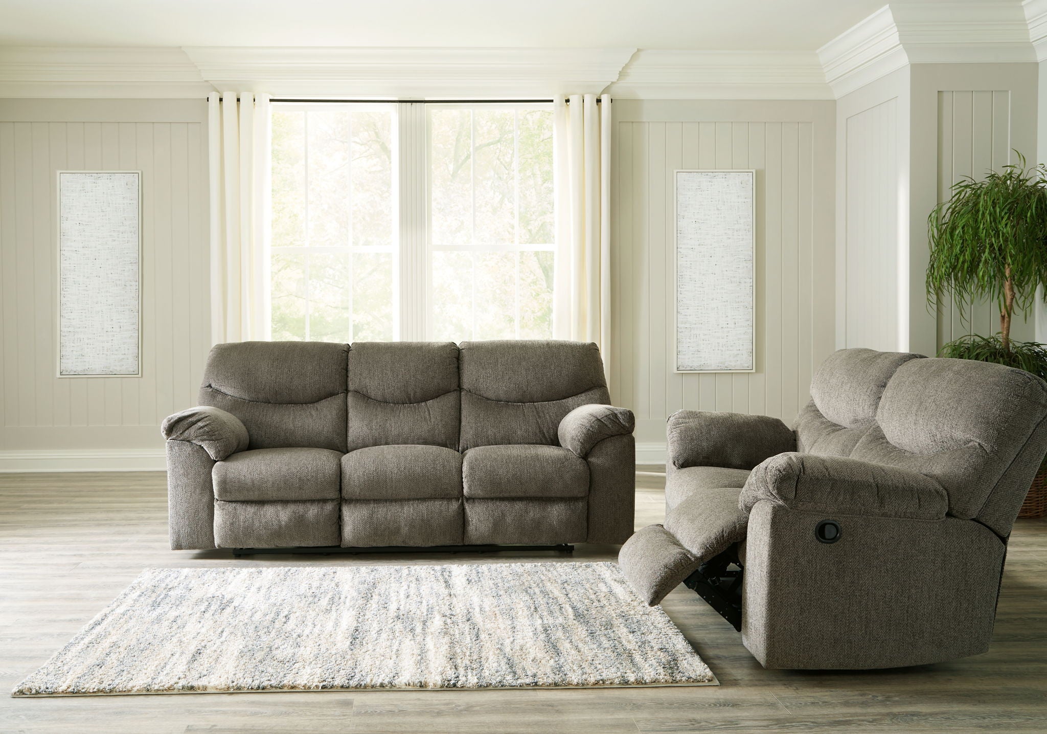 Taupe fabric sofa with matching recliner chair on an open seating rug