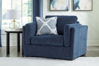 Blue armchair with wide arms and a striped throw pillow