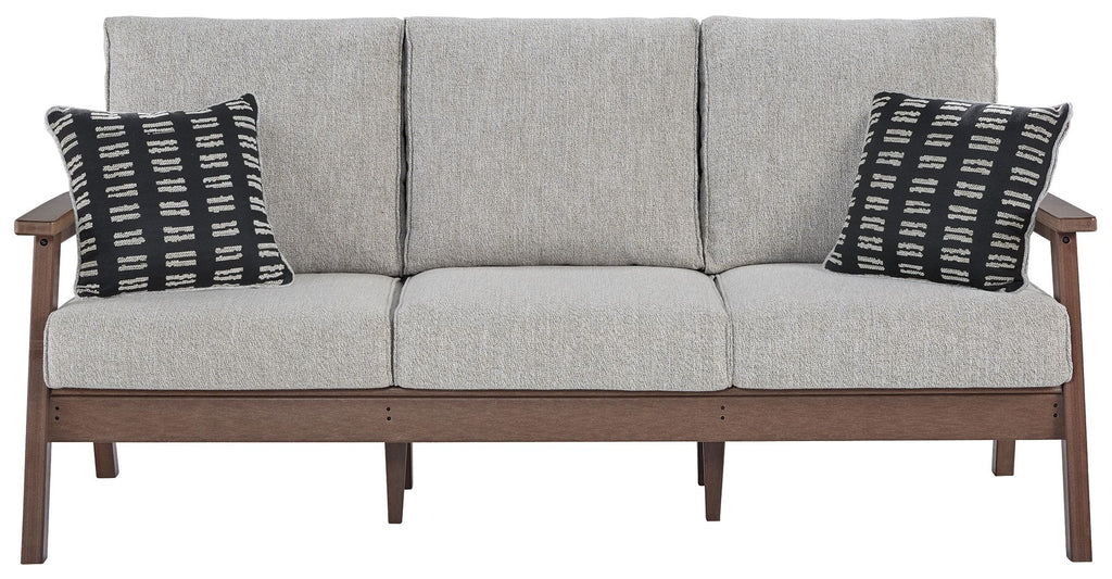 Grey upholstered sofa with three seat cushions and two black-and-white throw pillows