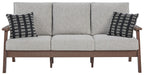 Grey upholstered sofa with three seat cushions and two black-and-white throw pillows
