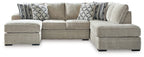 Beige corner chaise sectional sofa with patterned throw pillows on a chaise platform