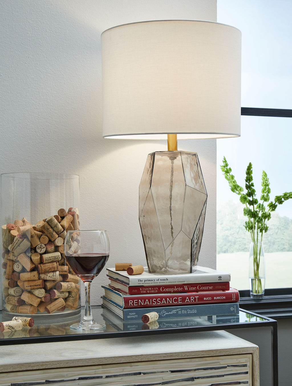 Glass table lamp with white drum shade and geometric gray faceted base