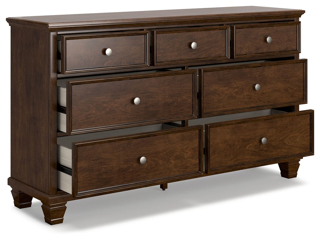 Brown dresser with several drawers and round knobs, raised panel trim