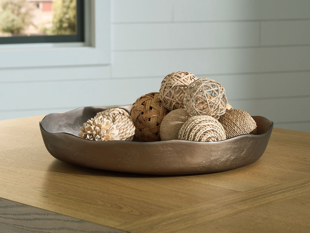 Champagne gold decorative tray holding woven balls and dried flowers