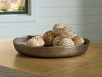 Champagne gold decorative tray holding woven balls and dried flowers