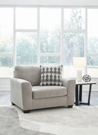 Gray upholstered armchair with patterned lumbar pillow and solid throw pillow