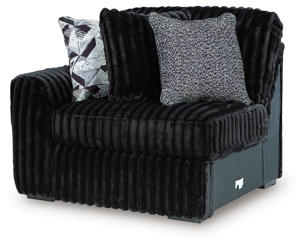 Black corduroy left-arm corner chair with textured back cushion and geometric throw pillow