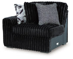 Black corduroy left-arm corner chair with textured back cushion and geometric throw pillow