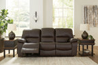 Dark brown reclining sofa with split seats, padded armrests, and recline footrests visible