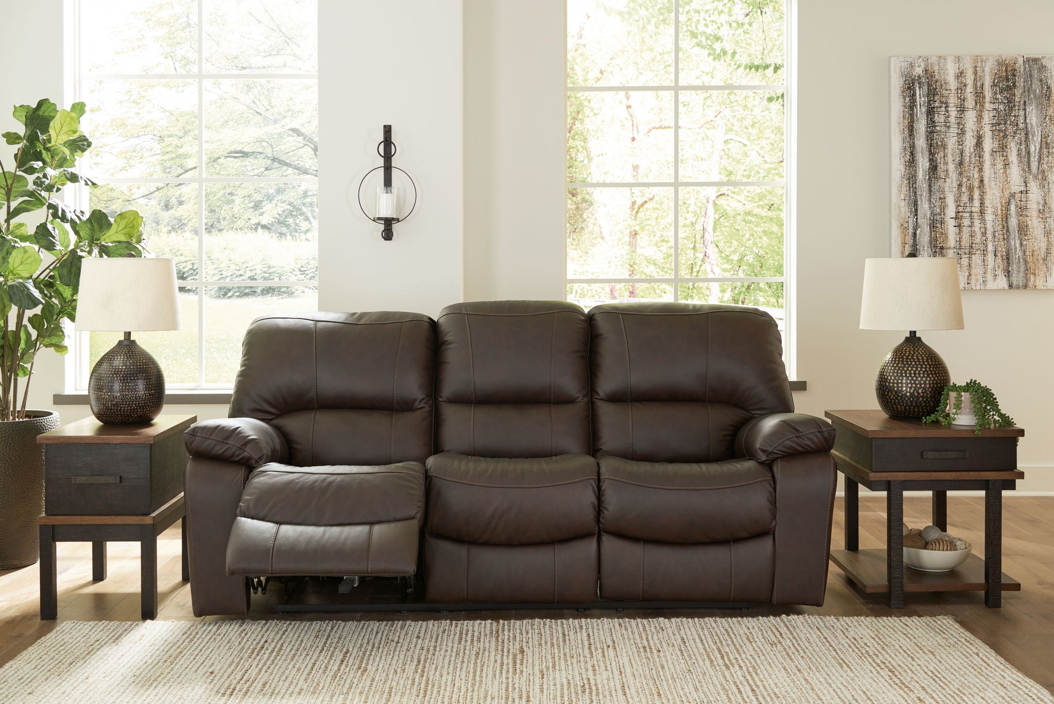 Dark brown reclining sofa with split seats, padded armrests, and recline footrests visible