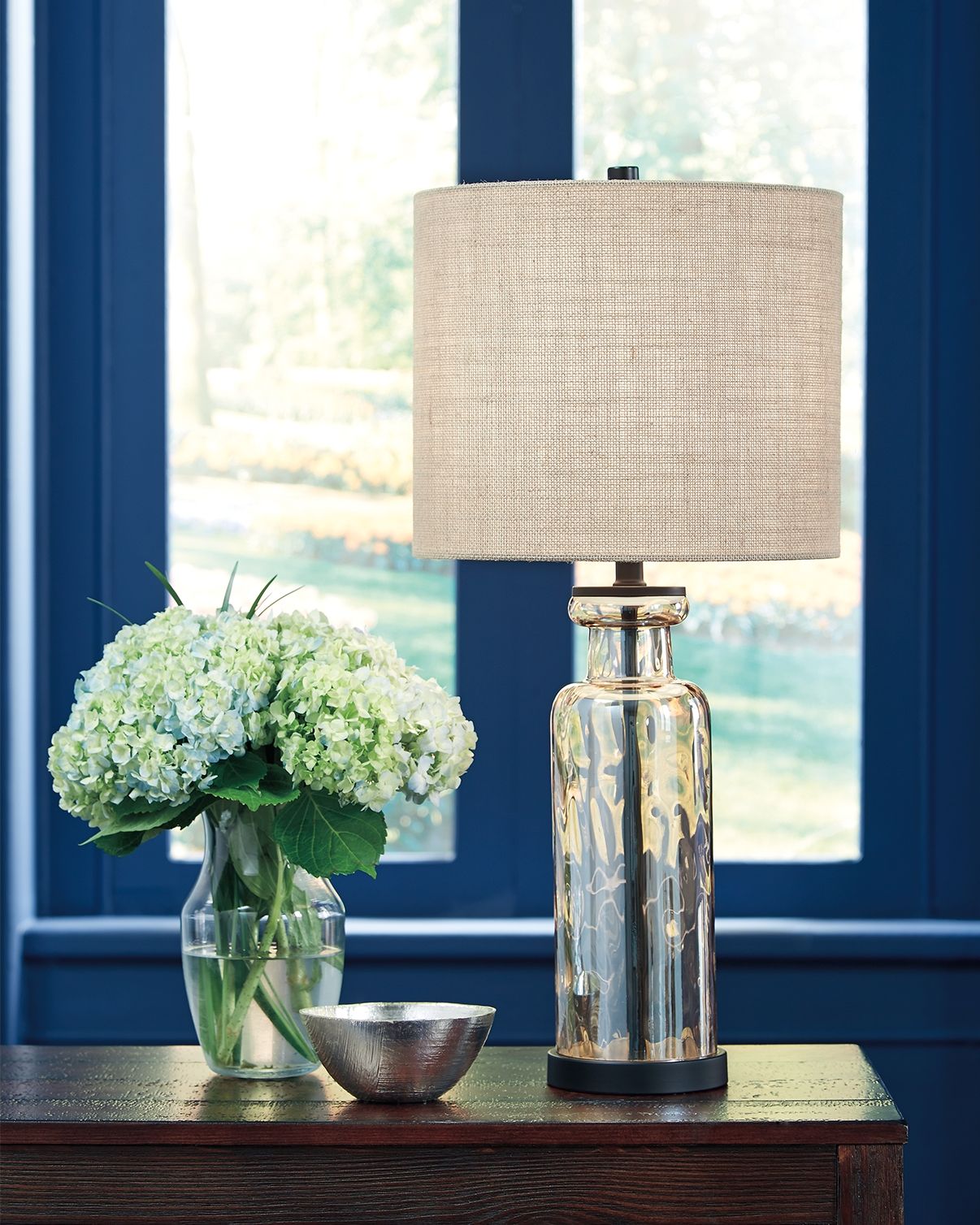Glass table lamp with champagne drum shade and reflective amber glass body