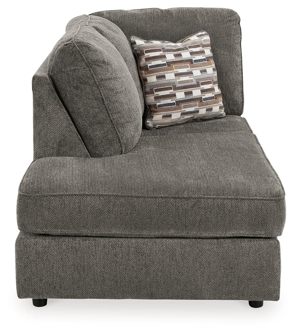 Gray corner chaise with curved back cushion and patterned throw pillow