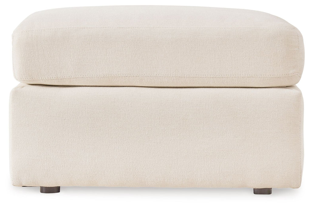 Cream accent ottoman with cushioned top and square base, low dark legs.