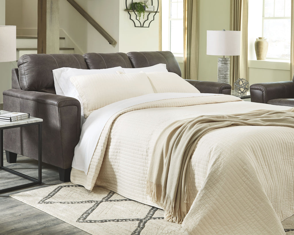 Dark gray sleeper sofa with mattress extended and bed side armrest
