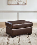 Dark brown ottoman with cushioned top and padded sides, shown with block feet