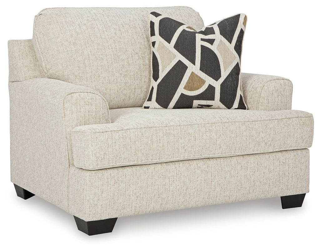 Beige upholstered loveseat with arms and dark geometric throw pillow
