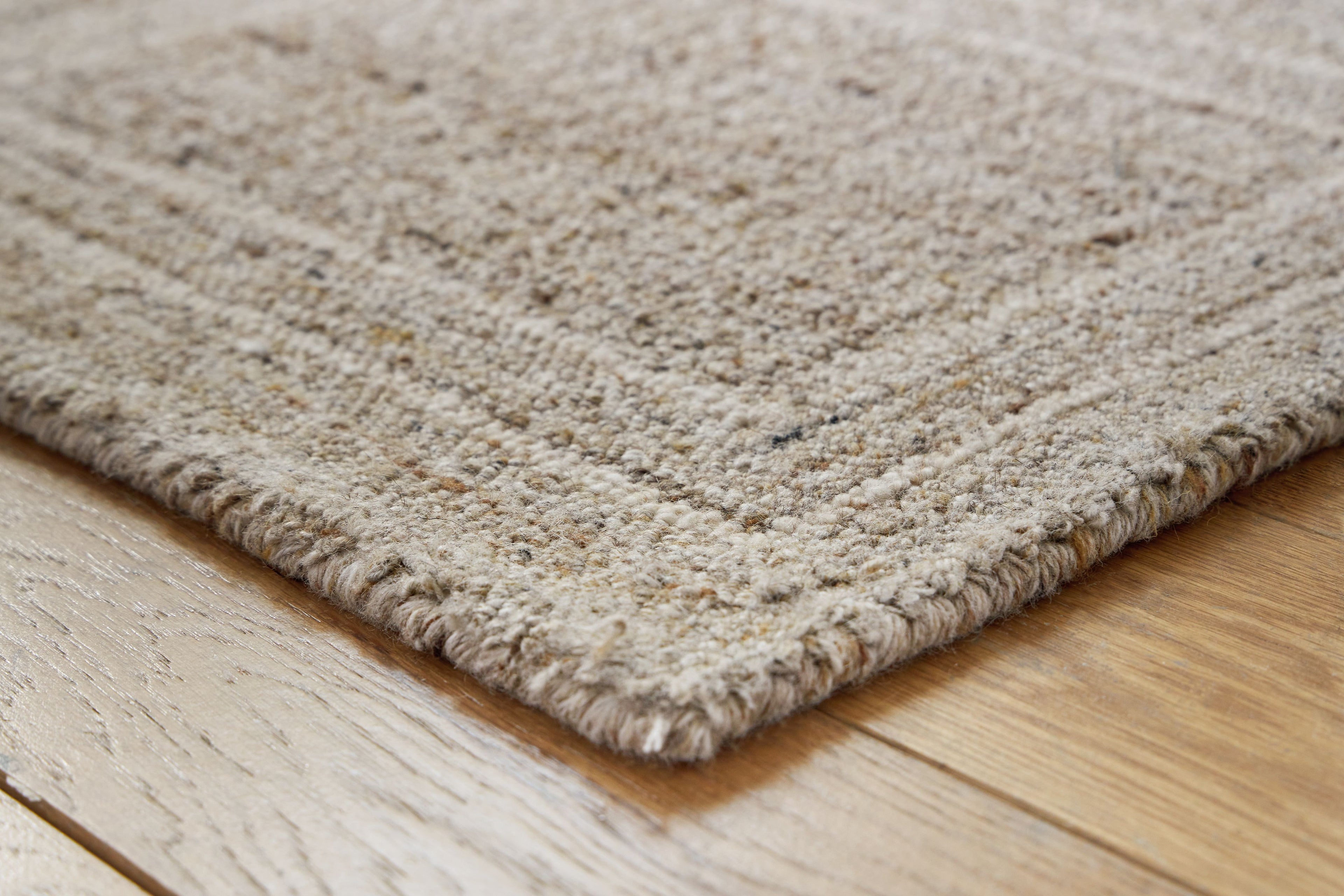 Gray area rug corner with short textured fibers