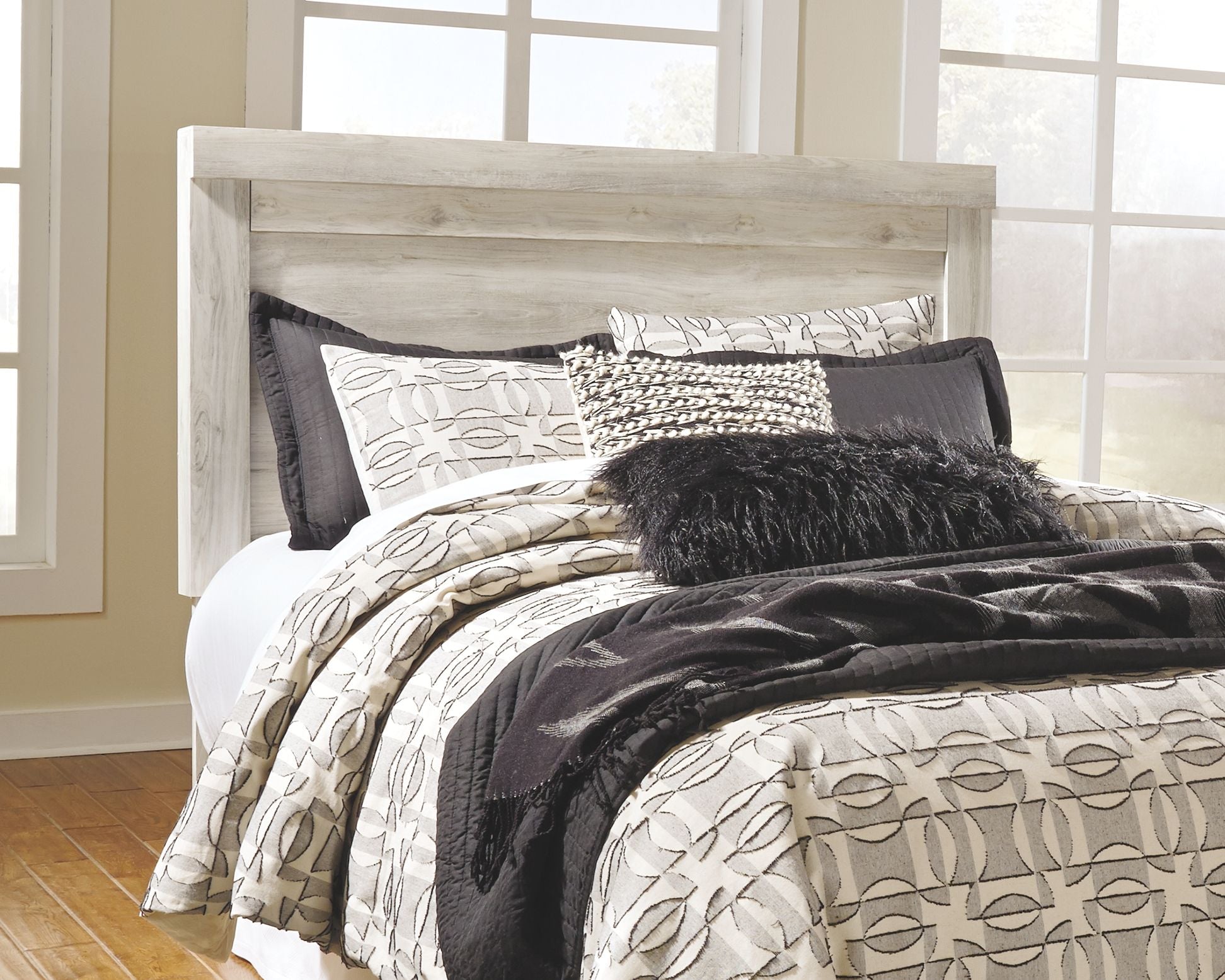Beige panel headboard with bolt-on metal bed frame and layered pillows