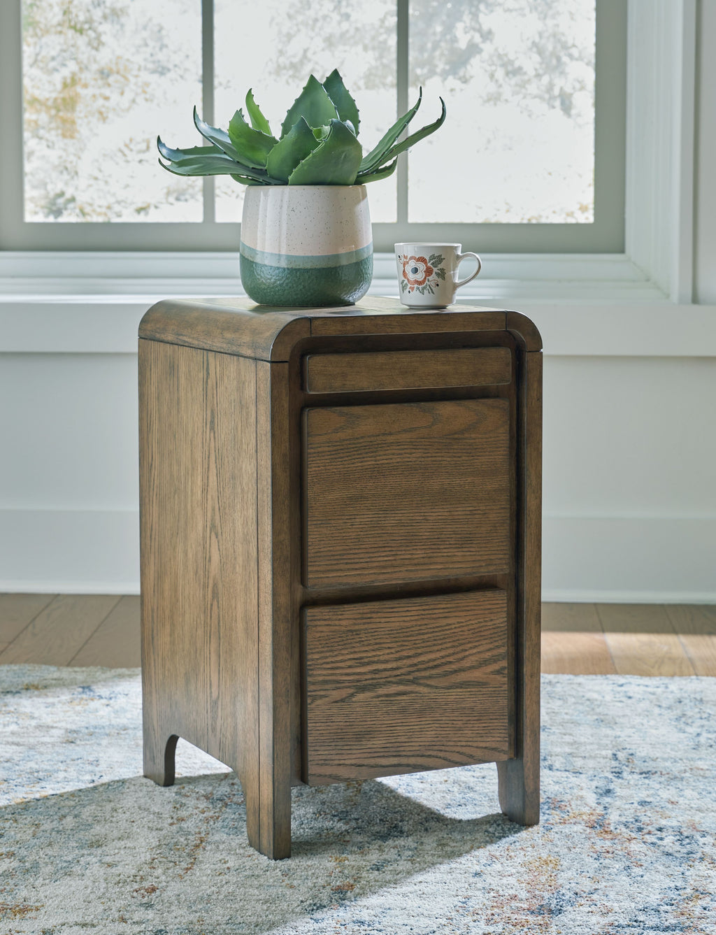 Brown wooden accent table with two-panel cabinet front and tapered legs