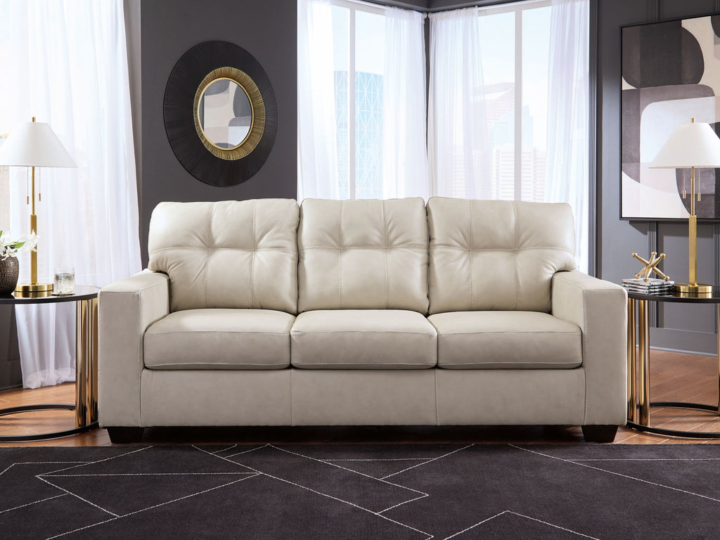 Beige sofa with tufted back and three padded seat cushions