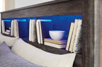 Bookcase headboard shelves with books and decor against dark wood backing