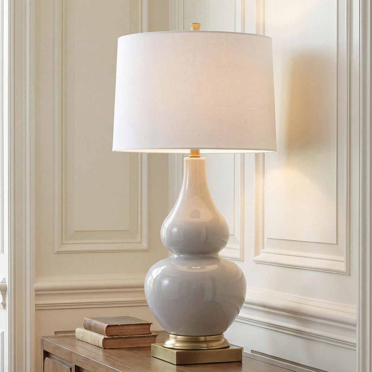 Ceramic table lamp, cream fabric shade over gray ceramic urn base with gold pedestal