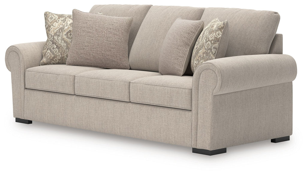 Heather fabric sofa in light beige with patterned and solid throw pillows, rounded armrests