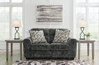 Gunmetal gray loveseat in textured upholstery with matching patterned throw pillows