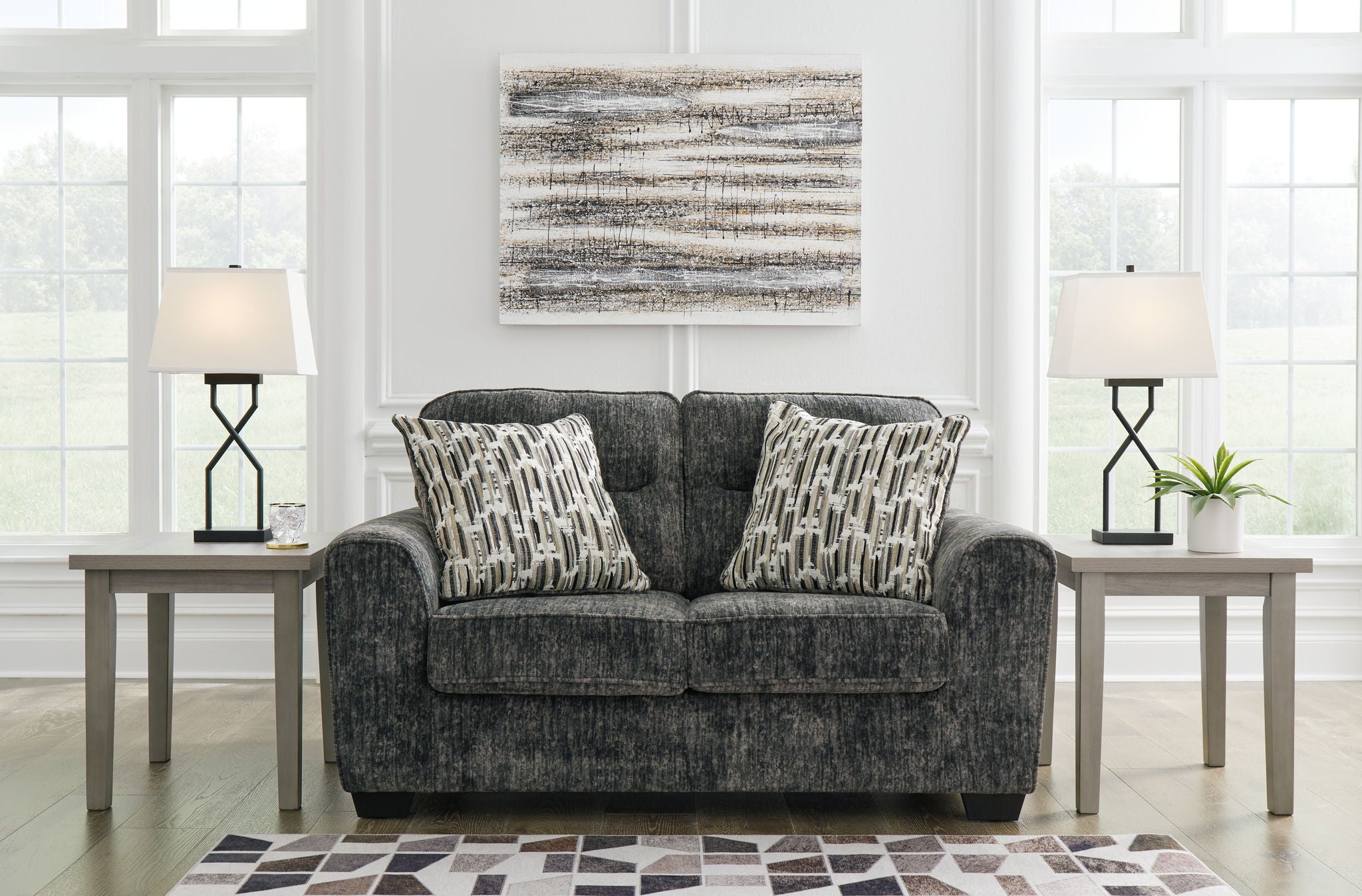 Gunmetal gray loveseat in textured upholstery with matching patterned throw pillows