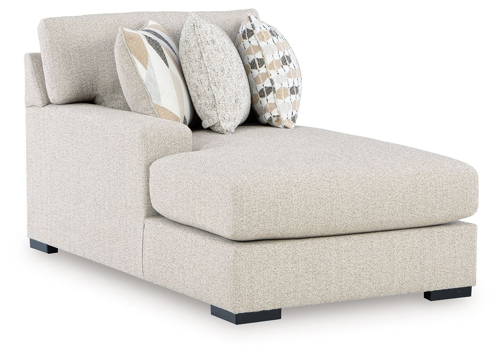 Light pebble fabric corner chaise with squared arms, black legs, and patterned throw pillows