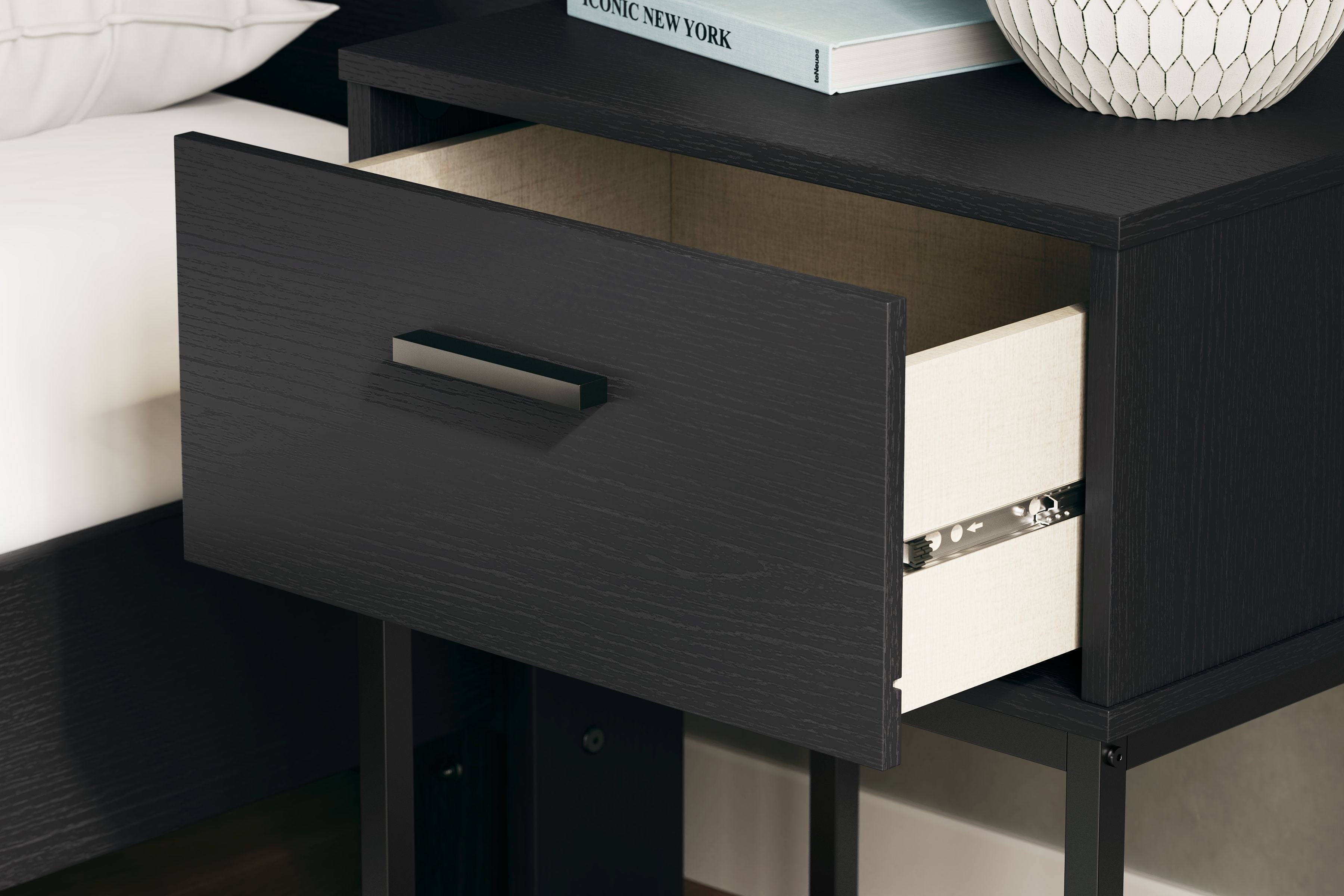 Black night stand with one drawer and dark bar handle, viewed from above.