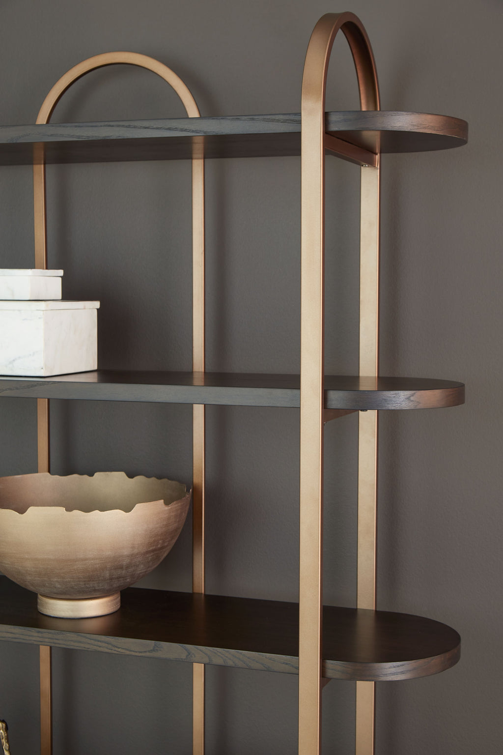 Brown bookcase with tall arched sides and horizontal shelves, angled view