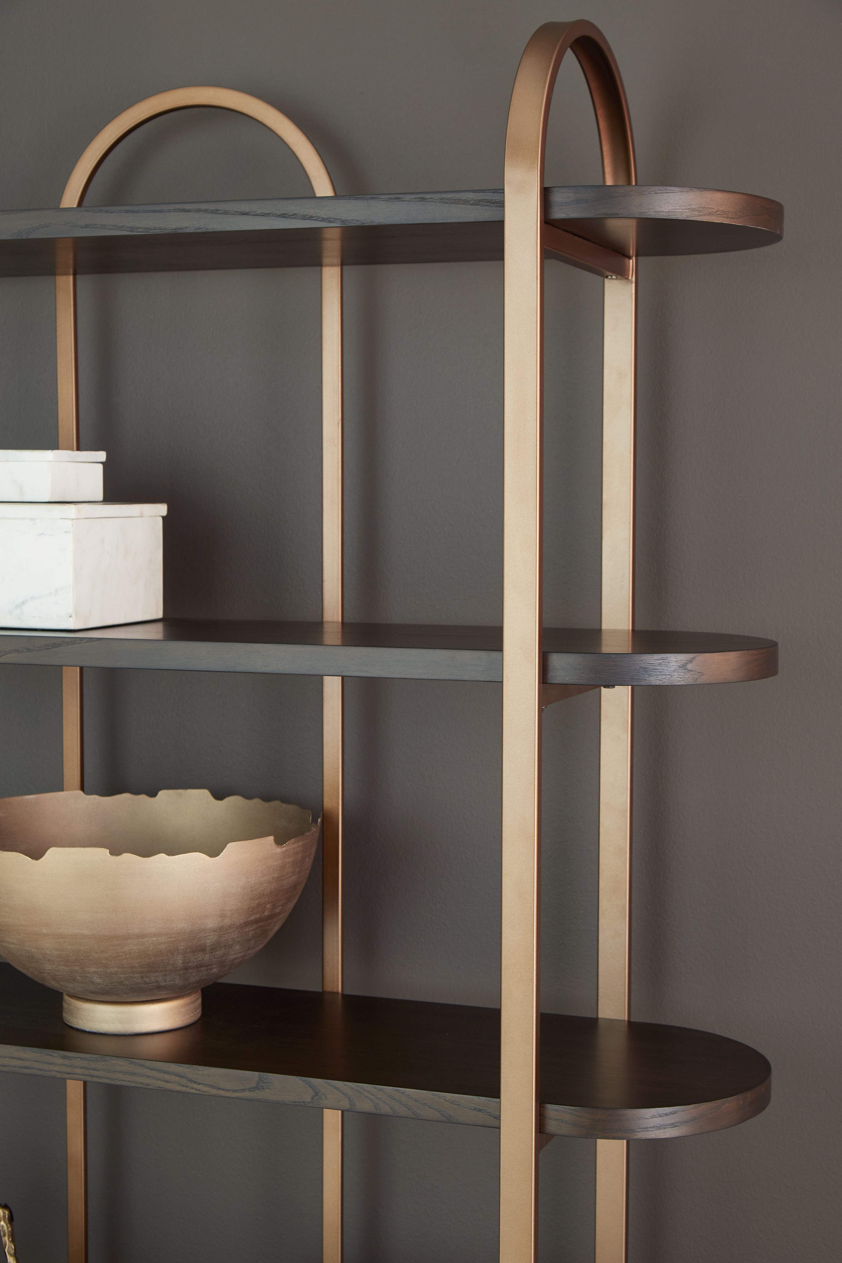 Brown bookcase with tall arched sides and horizontal shelves, angled view