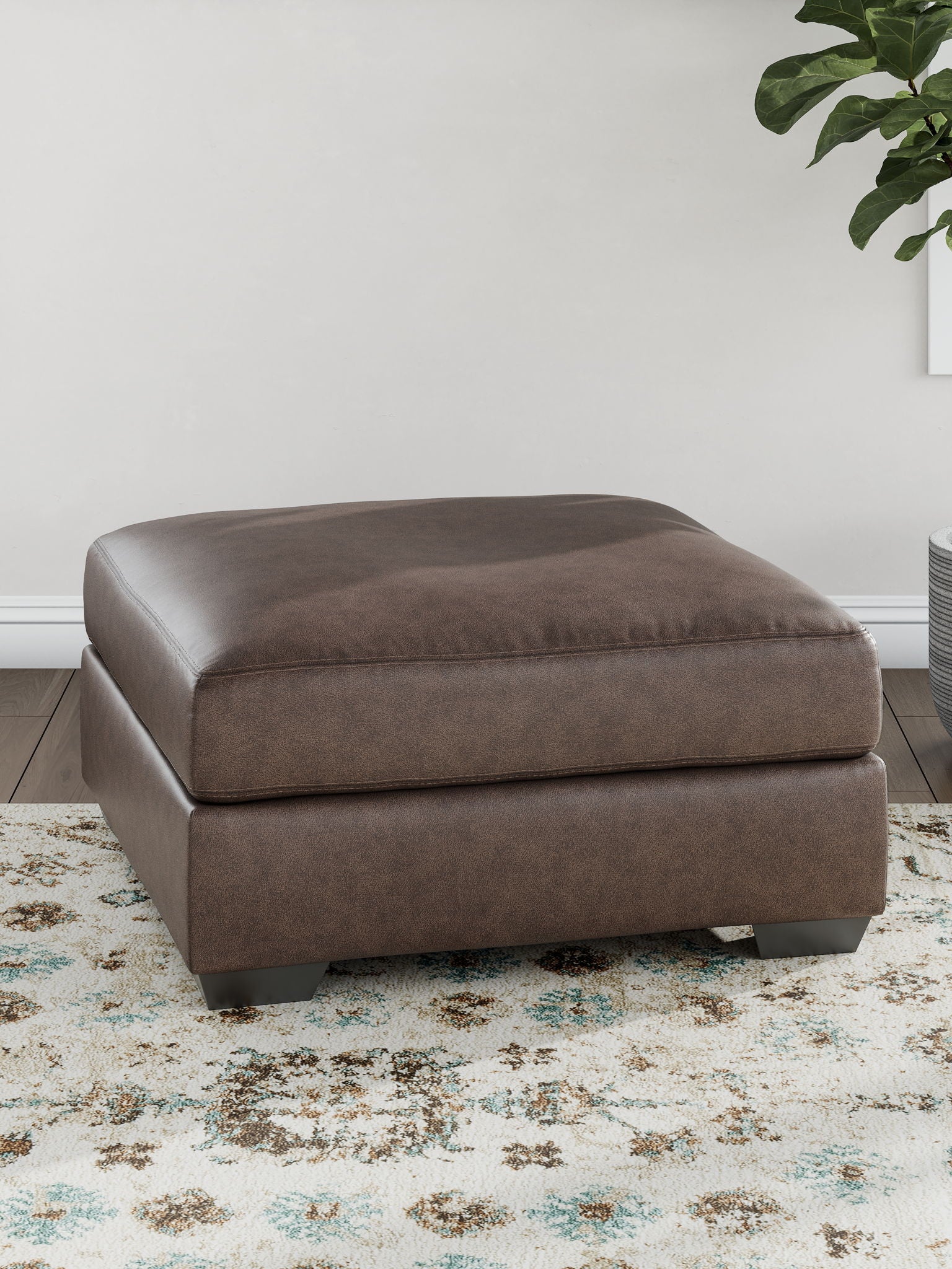 Oversized accent ottoman in dark brown with low block legs, upholstered top