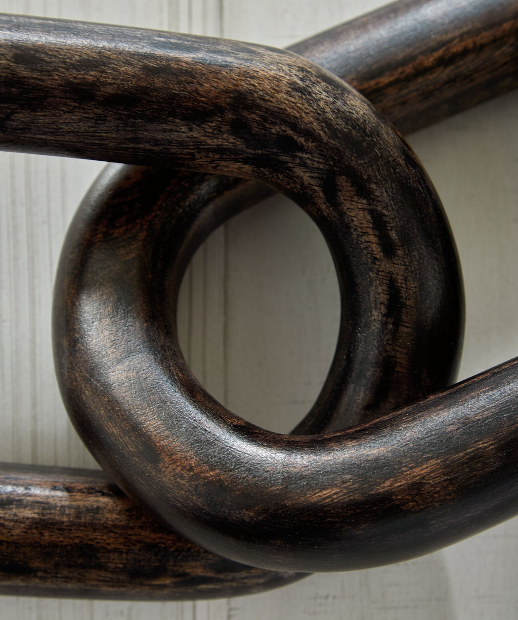 Dark chain sculpture with overlapping oval links and rustic finish