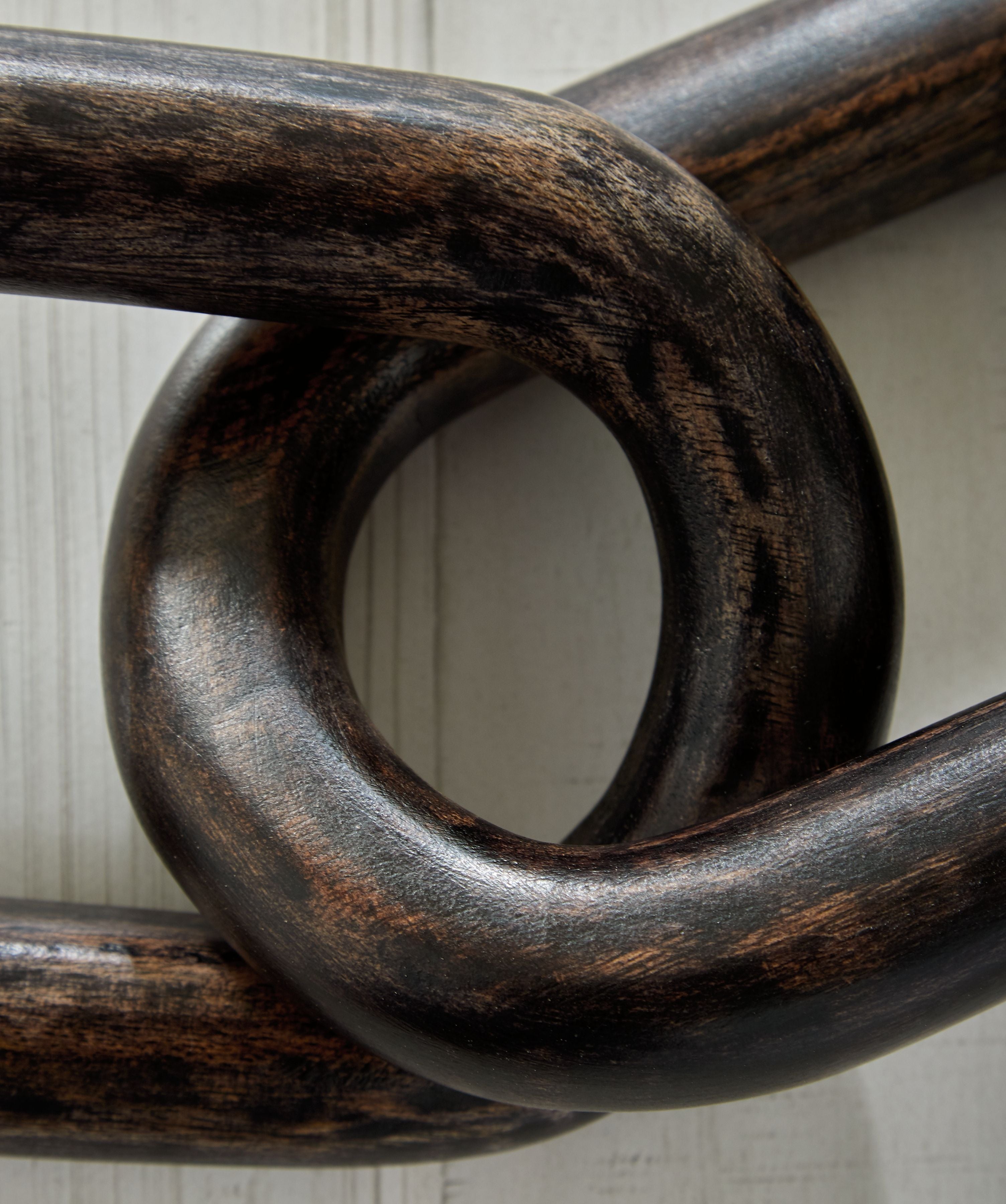 Dark chain sculpture with overlapping oval links and rustic finish